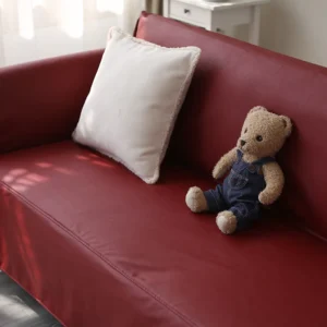 Jeté de canapé simili cuir rouge bordeaux sur l'assise, avec coussin blanc