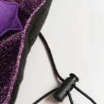 Gros plan sur l’élastique d’une robe de sorcier violette pour chat.
