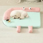 Un petit bichon dormant sur un coussin pour chien au design cartoon