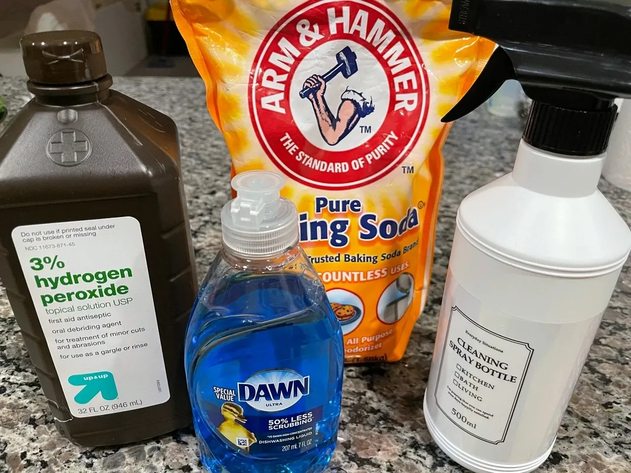 Comment Enlever l'Urine de Chat sur le Canapé et le Matelas : Solution Efficace Photo des trois ingrédients disposés côte à côte : bouteille d'eau oxygénée 3%, paquet de bicarbonate de soude alimentaire, et liquide vaisselle au citron