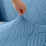 installation-housse-canape-bleu Gros plan motif ondulé du tissu jacquard, installation de la Housse Canapé Jacquard Ondulé bleue