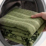 Housse verte d'escalier pour chien glissée dans un lave-linge