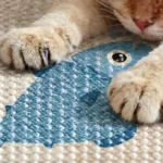 Pattes de chat posées sur le sisal d'un griffoir motif poisson bleu