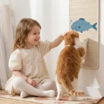 Petite fille qui caresse un chat roux en train de griffer un griffoir mural en sisal