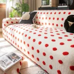 Housse canapé bouclette crème à pois rouges sur un canapé 3 places
