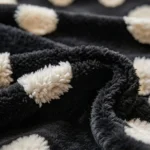 Gros plan sur la peluche bouclette noire et les pois blancs tuftés