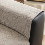 Jeté en chenille beige posé sur l’accoudoir d’un canapé