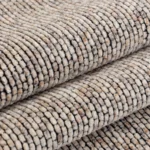 Tissage haute densité d’un jeté de canapé en chenille beige, résistant aux griffes