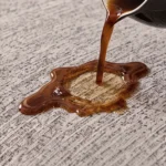 Café renversé qui reste en surface d'un jeté de canapé imperméable gris