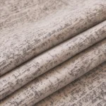 Gros plan sur la chenille grise chinée d'un jeté de canapé imperméable