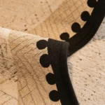 Bordure noire à pompons d'un jeté de canapé imperméable kaki