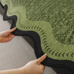 Bordure ondulée noire d'un jeté de canapé imperméable vert