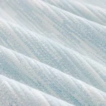 Gros plan sur le jacquard bleu ciel en relief du jeté de canapé